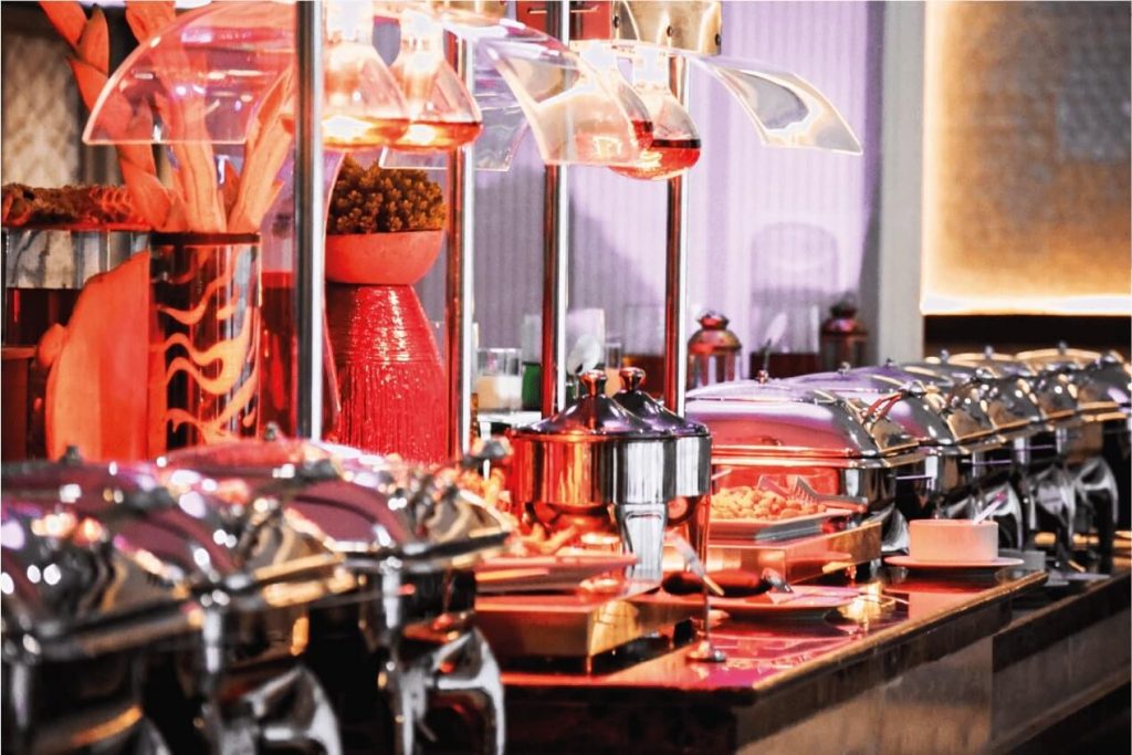 Lavish international buffet spread with live cooking station and chandeliers at Sapphire Plaza Hotel Doha